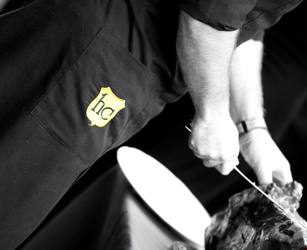 Corte de jamón con mandil bordado con el escudo de la Hostería de Castañeda