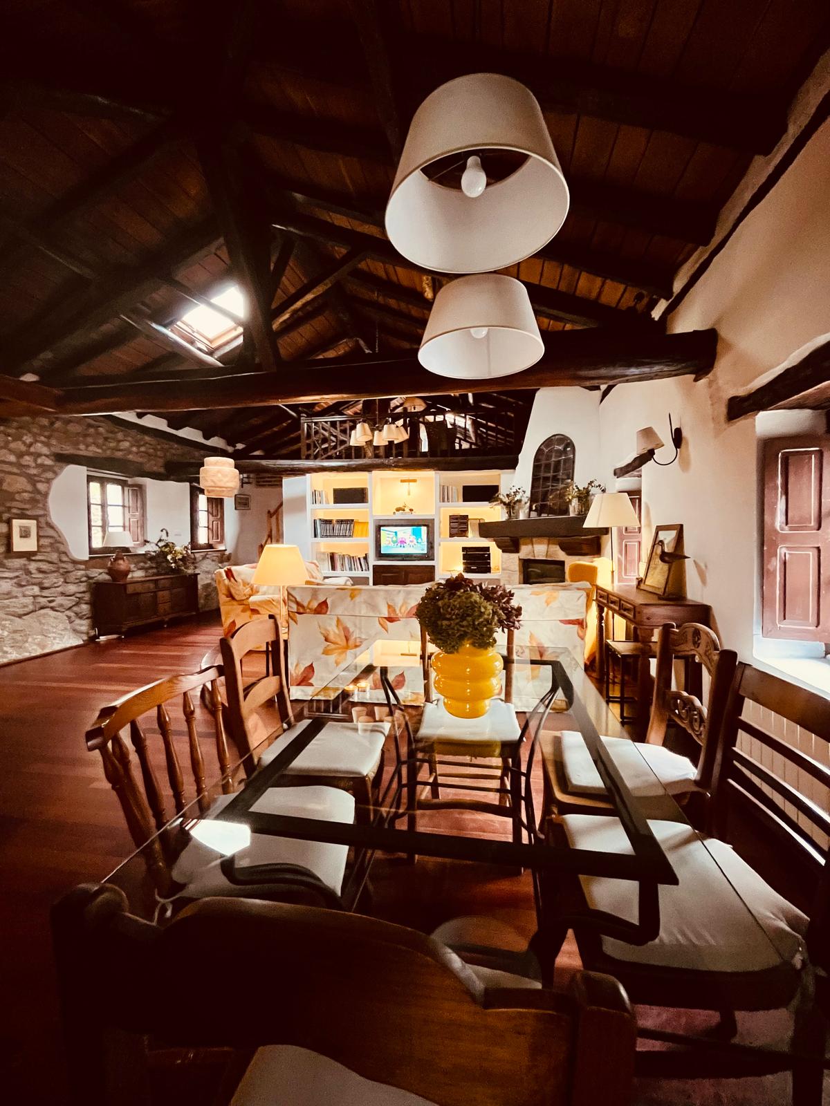 Salón comedor con techos de madera y vigas a la vista en casa rural de Puente Viesgo, Cantabria