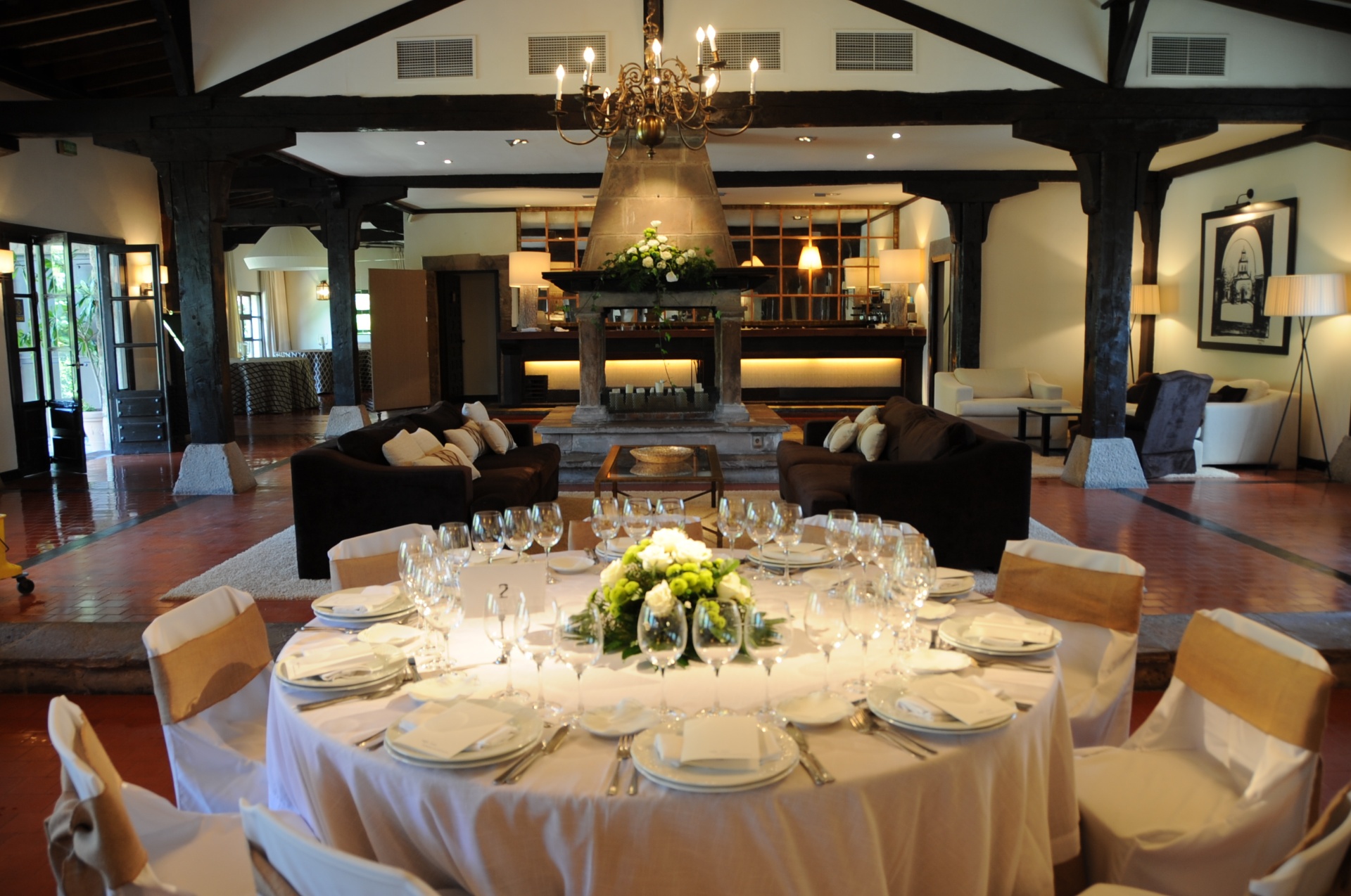 Salón principal de la Hostería de Castañeda con chimenea de piedra y mesa vestida para banquete