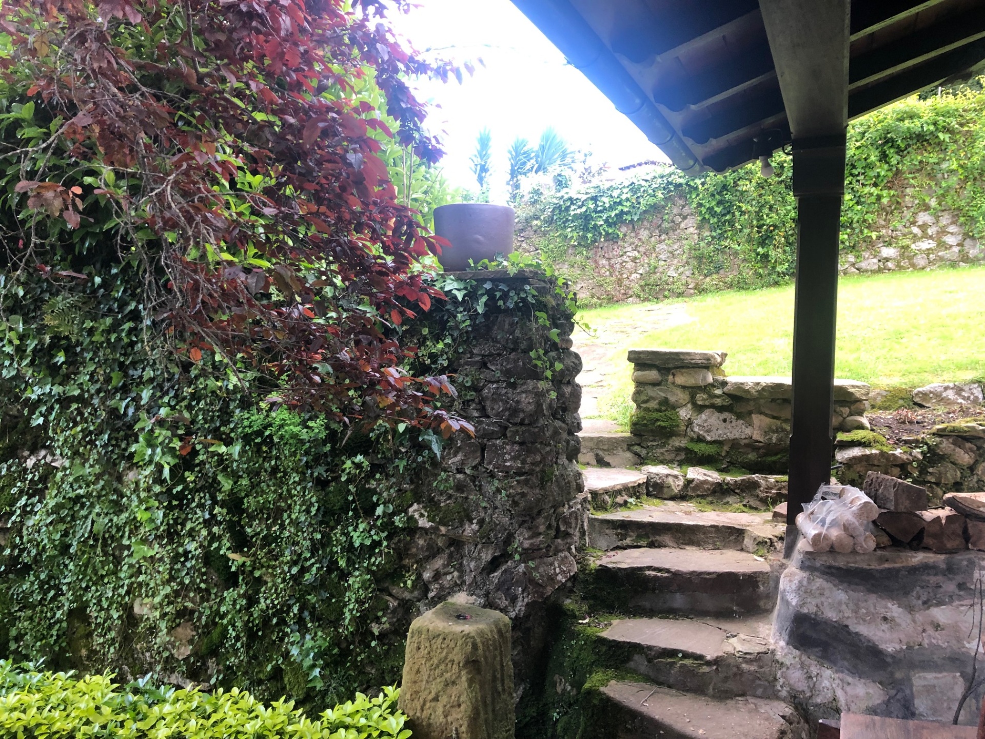 Porche de piedra y jardín en casa rural de Castañeda, Cantabria