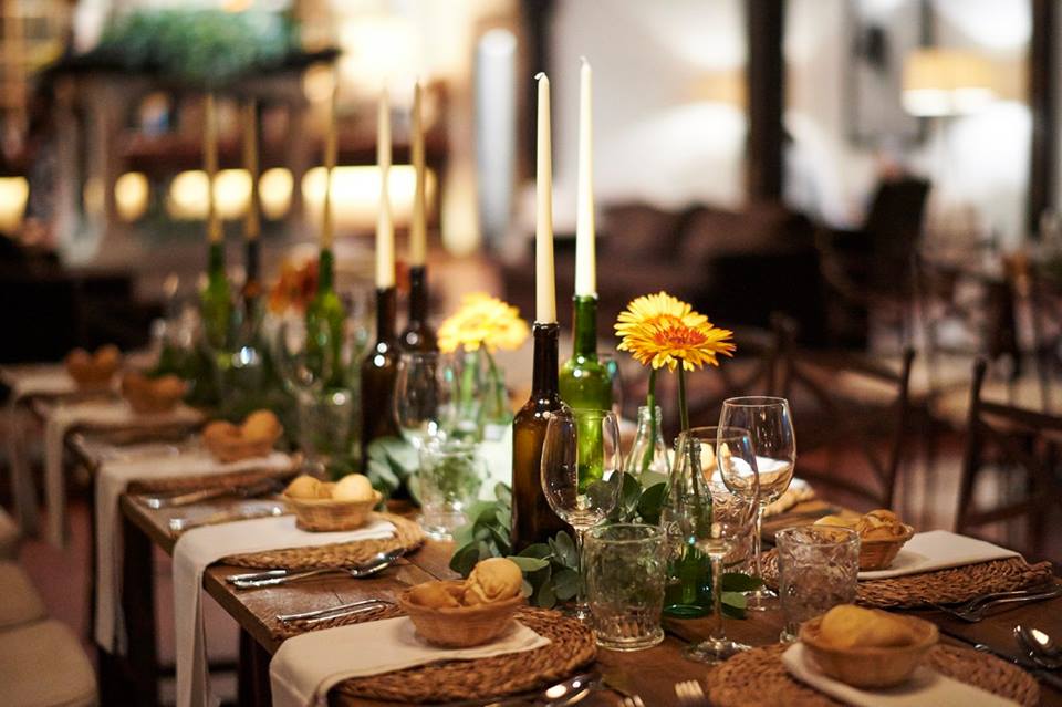 Detalle de mesa con copas, velas y flores en la Hostería de Castañeda