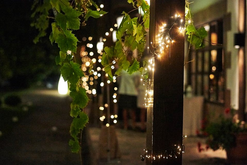 Luces cálidas entre la parra en la terraza de la Hostería de Castañeda