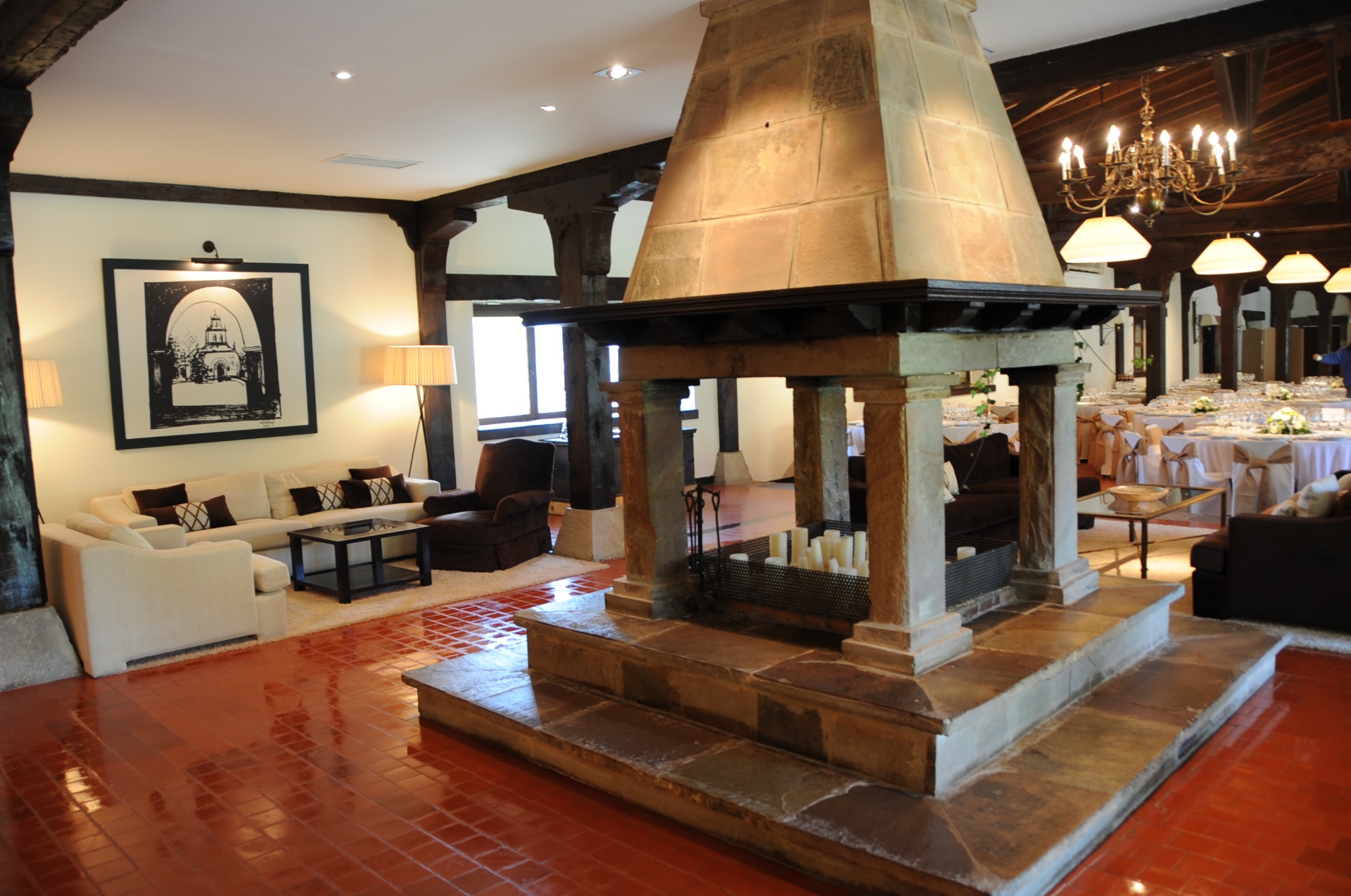 Salón con chimenea cónica de piedra y vigas de madera en la Hostería de Castañeda